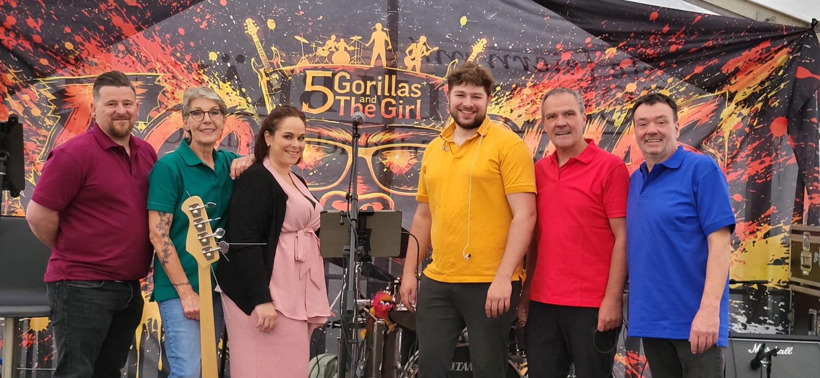 5 Gorillas & the Girl vor ihrem Bandbanner